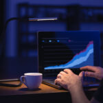 Businessman or broker looking at computer laptop analyzing about stock market invest trading stocks graph analysis. Trading online investment data price crypto currency market graph.